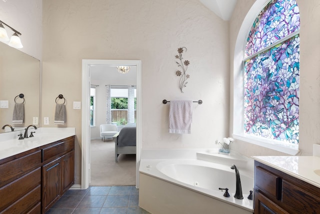 bathroom with tile patterned flooring, vanity, vaulted ceiling, and a bathing tub