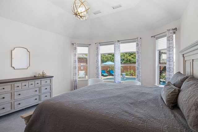 carpeted bedroom featuring a chandelier and vaulted ceiling