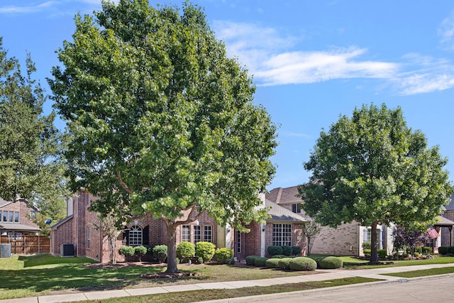 obstructed view of property featuring a front yard and central AC