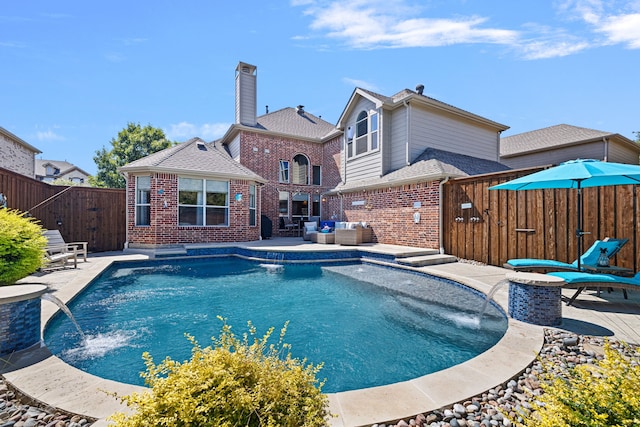 view of pool featuring pool water feature, a patio area, and outdoor lounge area