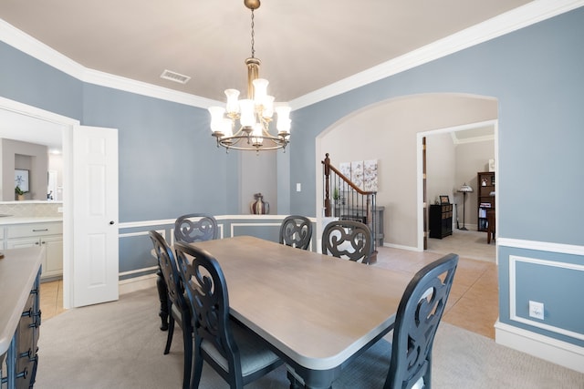 dining room featuring crown molding, light tile patterned flooring, and a chandelier