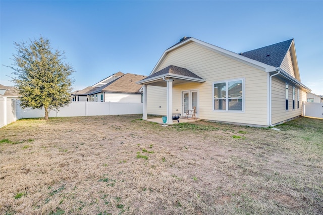 rear view of house featuring a patio and a lawn