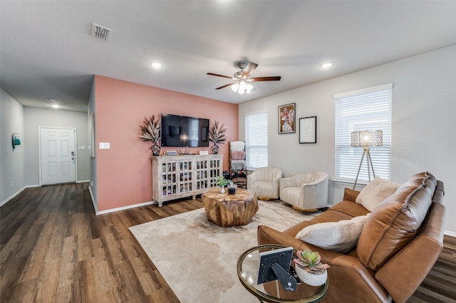 living room with ceiling fan and dark wood-type flooring