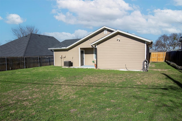 rear view of house featuring a yard and central air condition unit