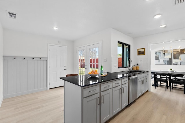 kitchen featuring stainless steel dishwasher, gray cabinets, sink, and light hardwood / wood-style flooring