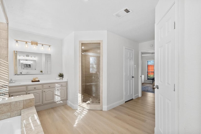 bathroom featuring hardwood / wood-style floors, vanity, and a shower with door