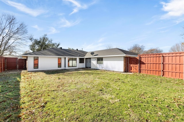 rear view of property featuring a yard