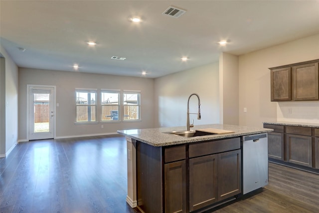 kitchen with light stone countertops, sink, stainless steel dishwasher, dark hardwood / wood-style floors, and a center island with sink