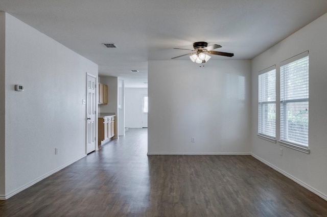 spare room with ceiling fan and dark wood-type flooring