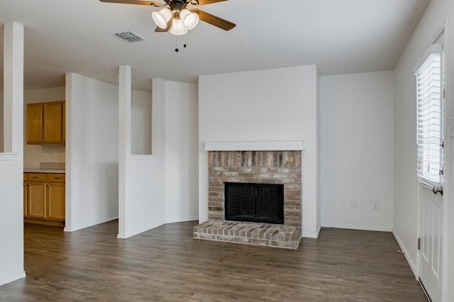 unfurnished living room featuring ceiling fan, dark hardwood / wood-style flooring, and a fireplace