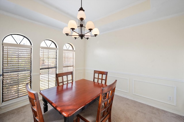 dining room featuring light carpet, an inviting chandelier, and ornamental molding