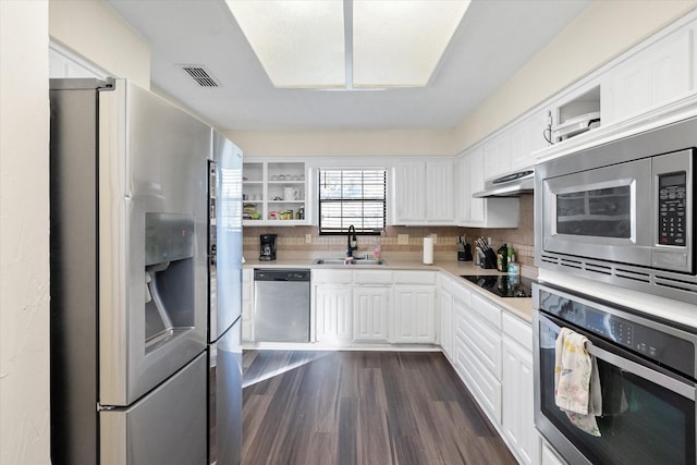 kitchen featuring backsplash, sink, dark hardwood / wood-style flooring, white cabinetry, and stainless steel appliances