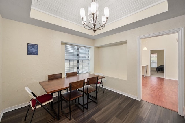 dining room with a notable chandelier, a tray ceiling, wooden ceiling, and dark hardwood / wood-style floors