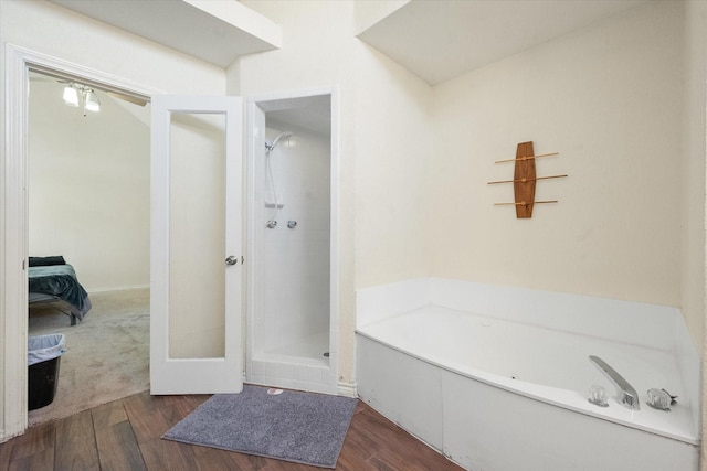 bathroom with hardwood / wood-style flooring and separate shower and tub