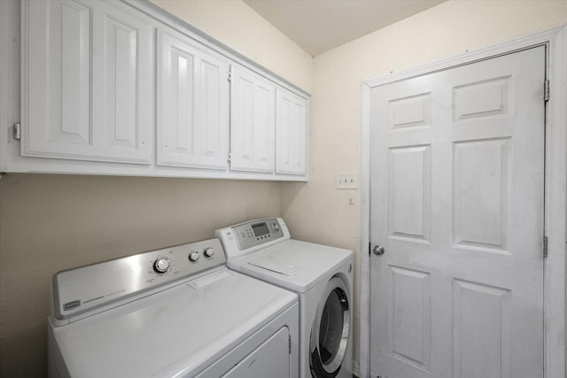 clothes washing area with cabinets and independent washer and dryer