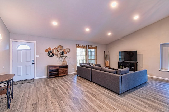 living room with light hardwood / wood-style floors and lofted ceiling