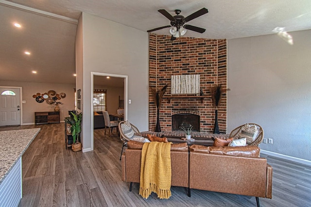 living room featuring a textured ceiling, ceiling fan, a fireplace, dark hardwood / wood-style floors, and lofted ceiling