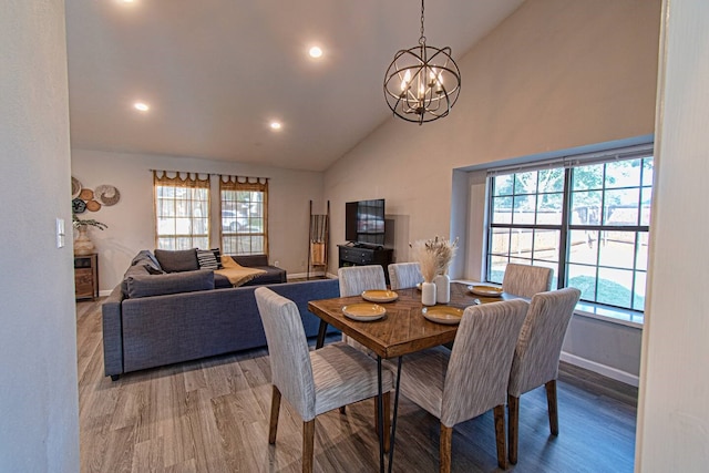 dining space featuring high vaulted ceiling, a chandelier, and hardwood / wood-style flooring