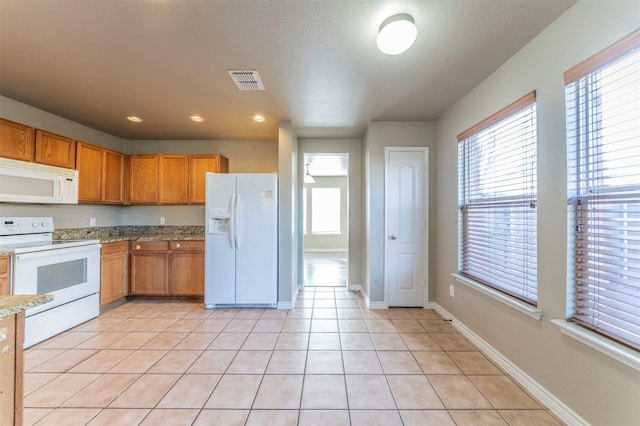 kitchen featuring light tile patterned flooring and white appliances