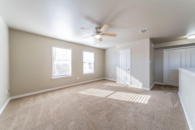 unfurnished room featuring light carpet and ceiling fan