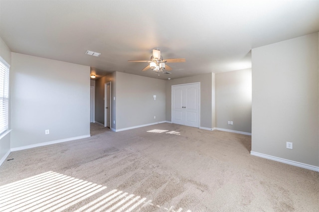 unfurnished room with light colored carpet and ceiling fan