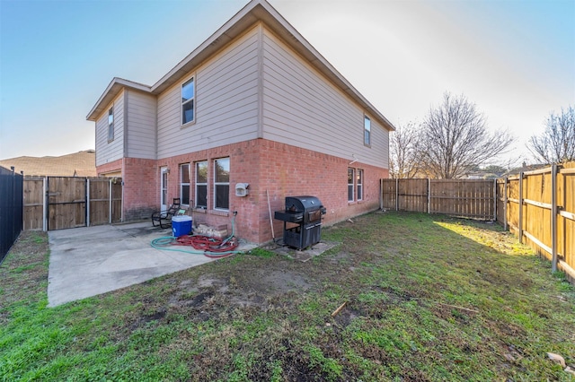 back of house featuring a lawn and a patio