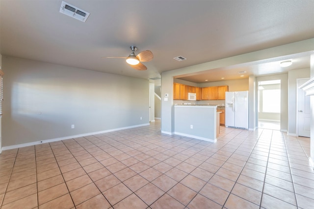 kitchen with light tile patterned floors, white appliances, and ceiling fan