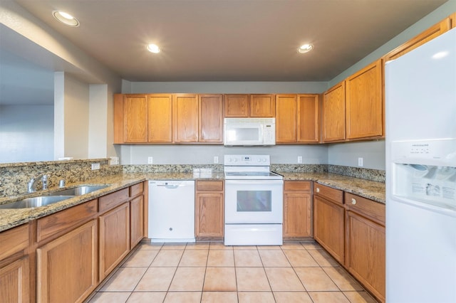 kitchen featuring light tile patterned flooring, light stone counters, white appliances, and sink