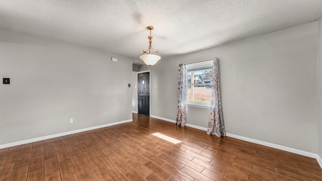 empty room featuring dark hardwood / wood-style flooring and a textured ceiling