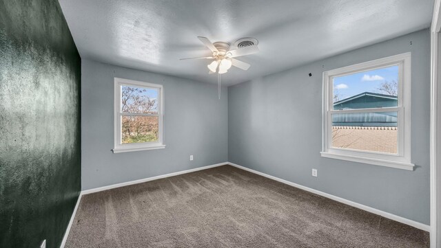 carpeted spare room featuring ceiling fan