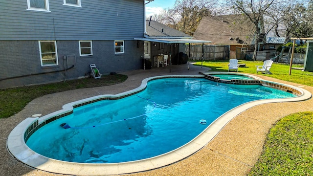 view of pool with a yard, a patio, and an in ground hot tub