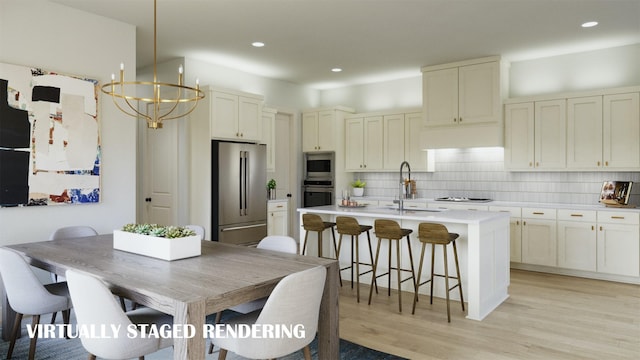 kitchen with sink, tasteful backsplash, light hardwood / wood-style flooring, a notable chandelier, and appliances with stainless steel finishes