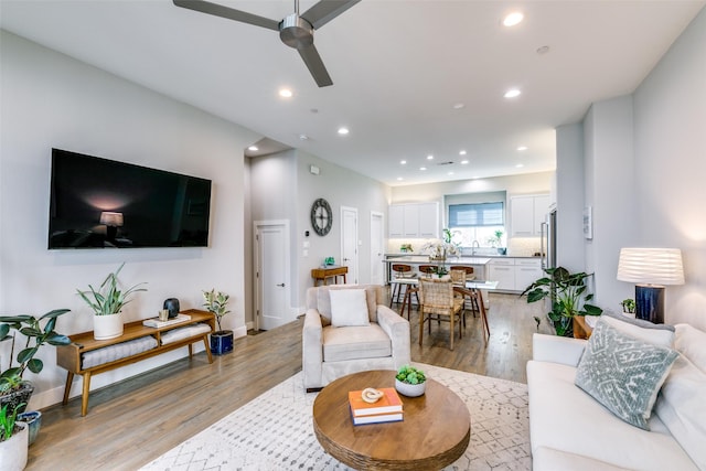 living room featuring ceiling fan and light hardwood / wood-style floors