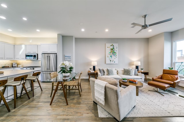 living room featuring ceiling fan and light hardwood / wood-style flooring