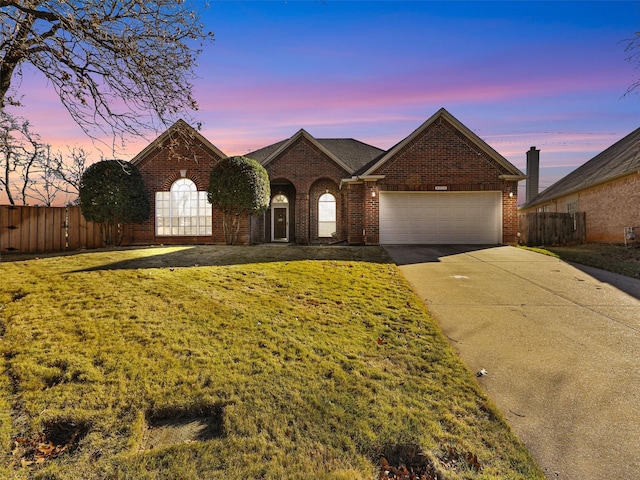 single story home featuring a garage and a lawn