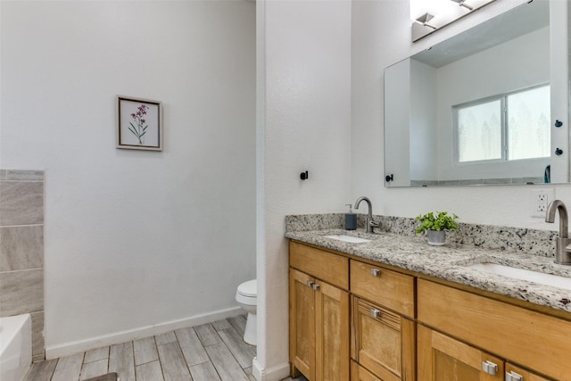 bathroom featuring wood-type flooring, vanity, toilet, and a bathing tub