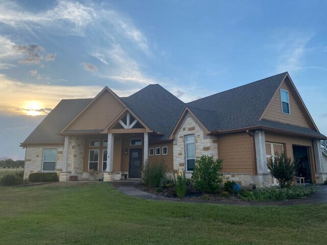 craftsman-style home with a garage and a yard