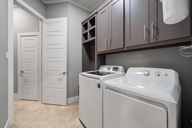 laundry area with cabinet space, baseboards, and washer and dryer