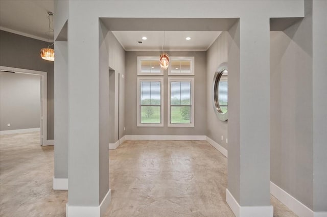 foyer featuring baseboards, concrete floors, and ornamental molding