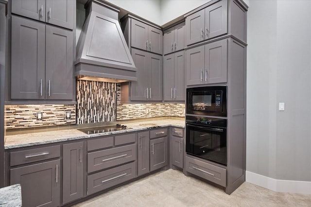 kitchen with tasteful backsplash, custom range hood, gray cabinetry, and black appliances