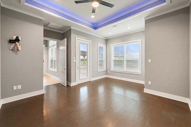 interior space featuring baseboards, visible vents, a ceiling fan, wood finished floors, and a raised ceiling