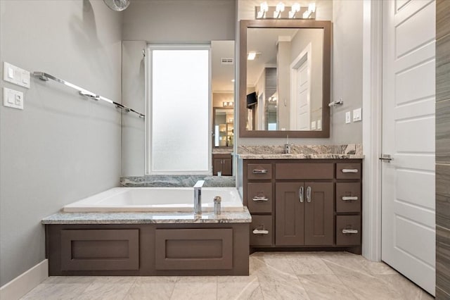 full bath with baseboards, a garden tub, marble finish floor, and vanity