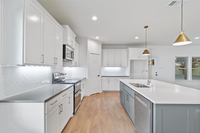 kitchen featuring white cabinets, appliances with stainless steel finishes, and sink