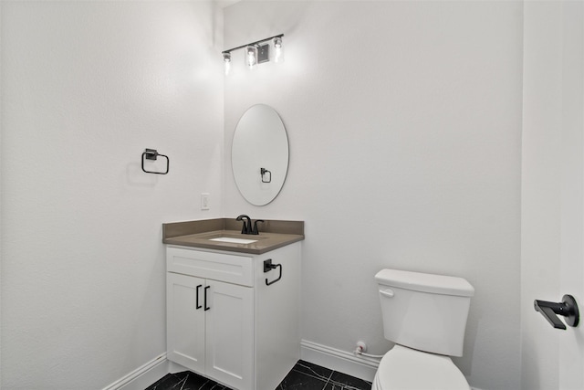 bathroom with tile patterned flooring, vanity, and toilet