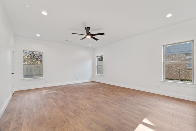 empty room with ceiling fan and light hardwood / wood-style floors