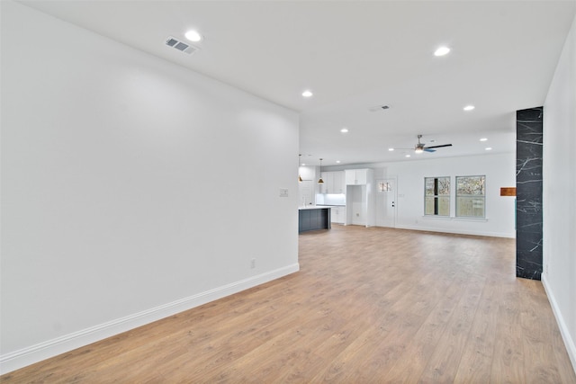 unfurnished living room with ceiling fan and light hardwood / wood-style flooring