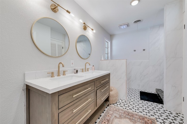 bathroom with vanity and a tile shower