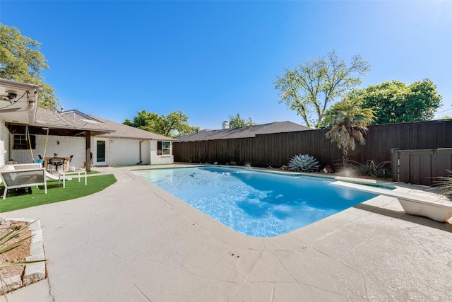 view of pool with a diving board and a patio area