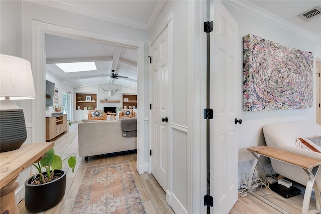 hallway featuring crown molding and vaulted ceiling with skylight