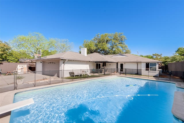 view of swimming pool with a diving board